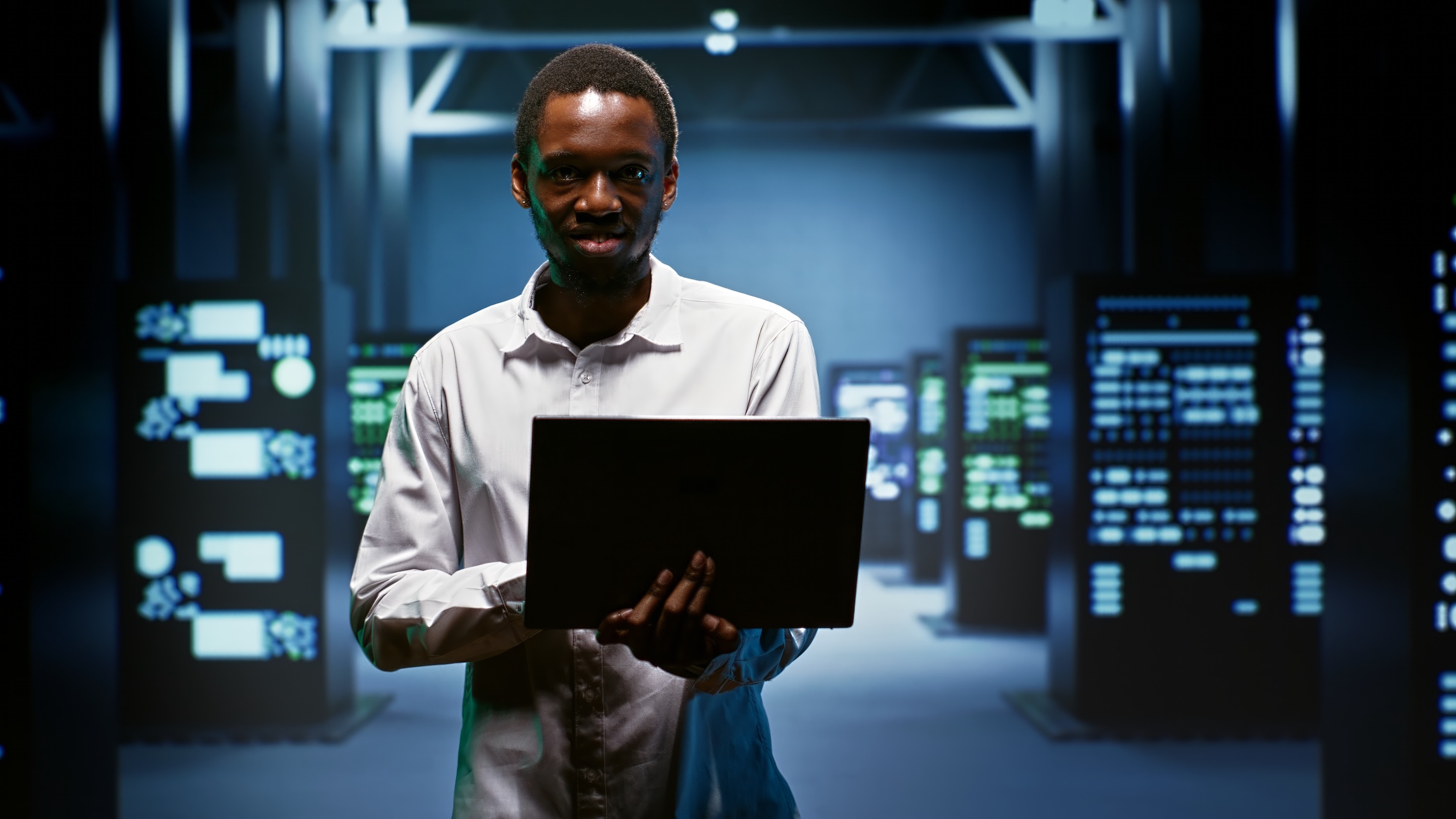 man holding laptop in server room 2026 03 19 01 59 54 utc